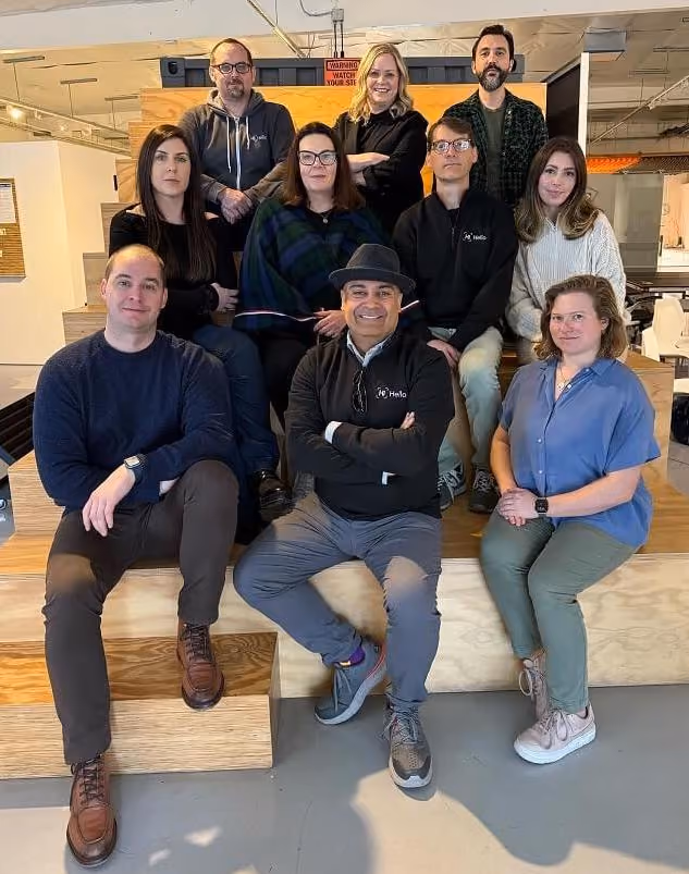HiHello's leadership team sitting on bleachers at HiHello HQ in Palo Alto, California.