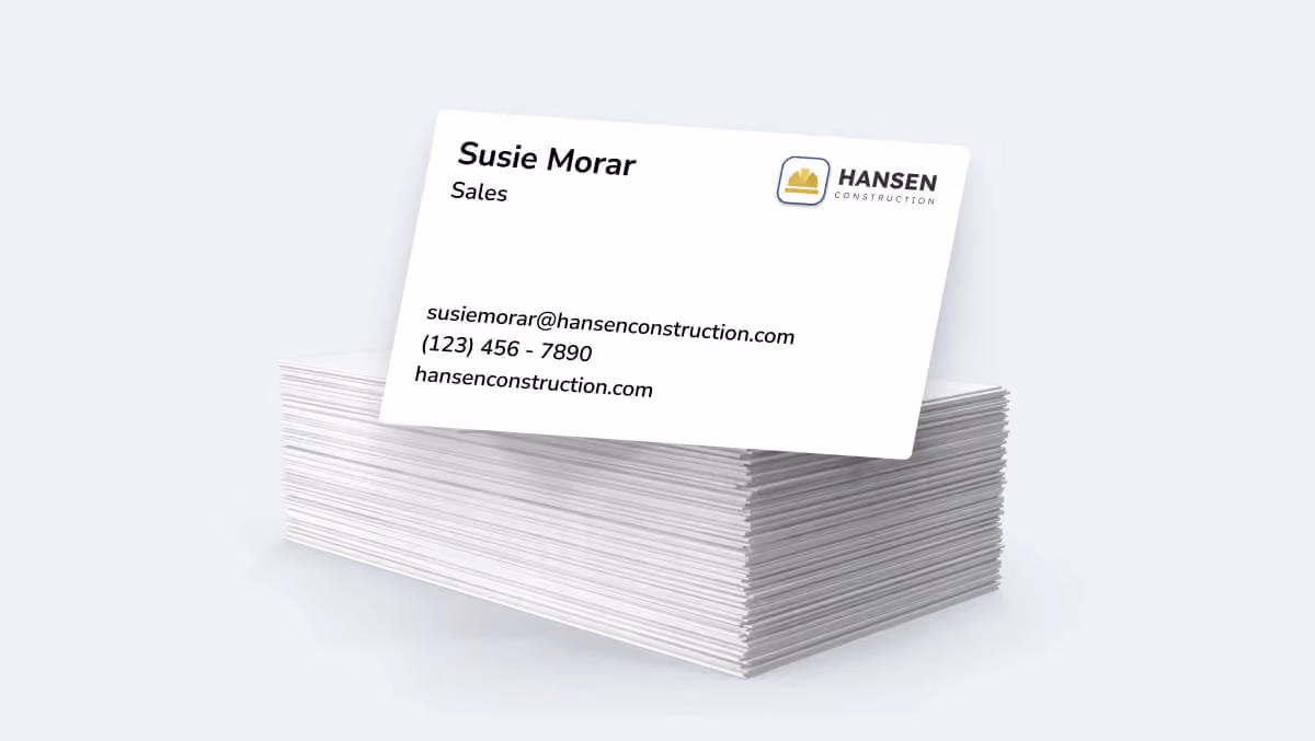 A stack of traditional paper business cards with printed contact details.