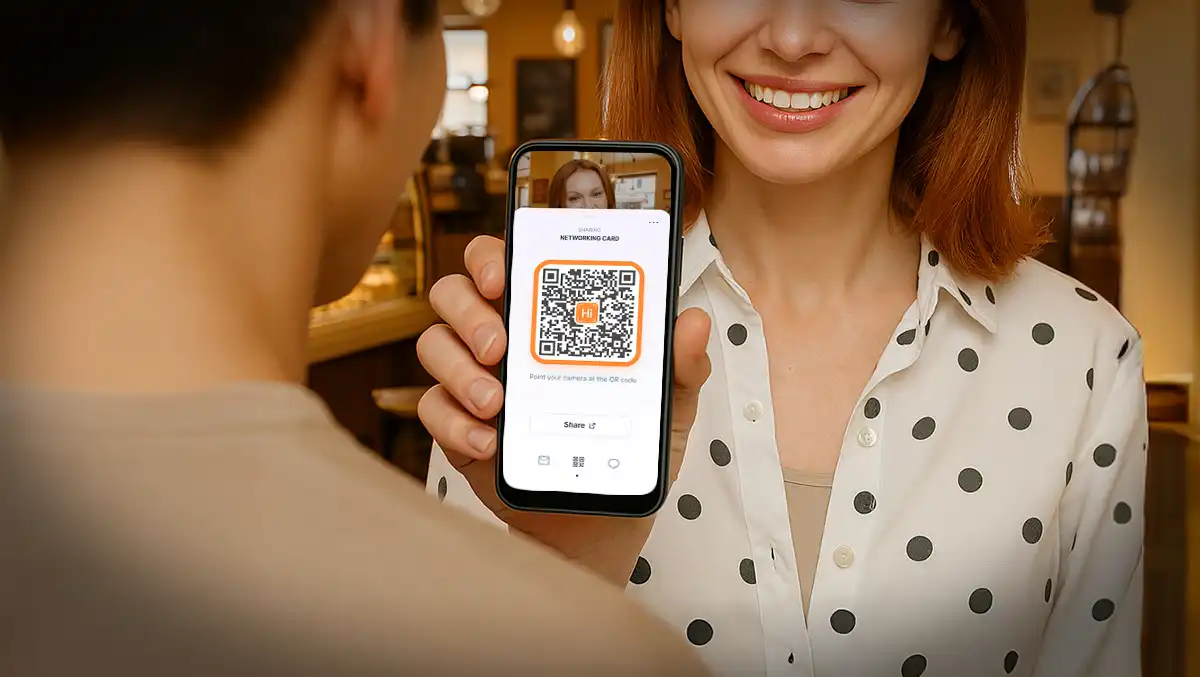 Woman showing her digital business card QR code on a phone to another person