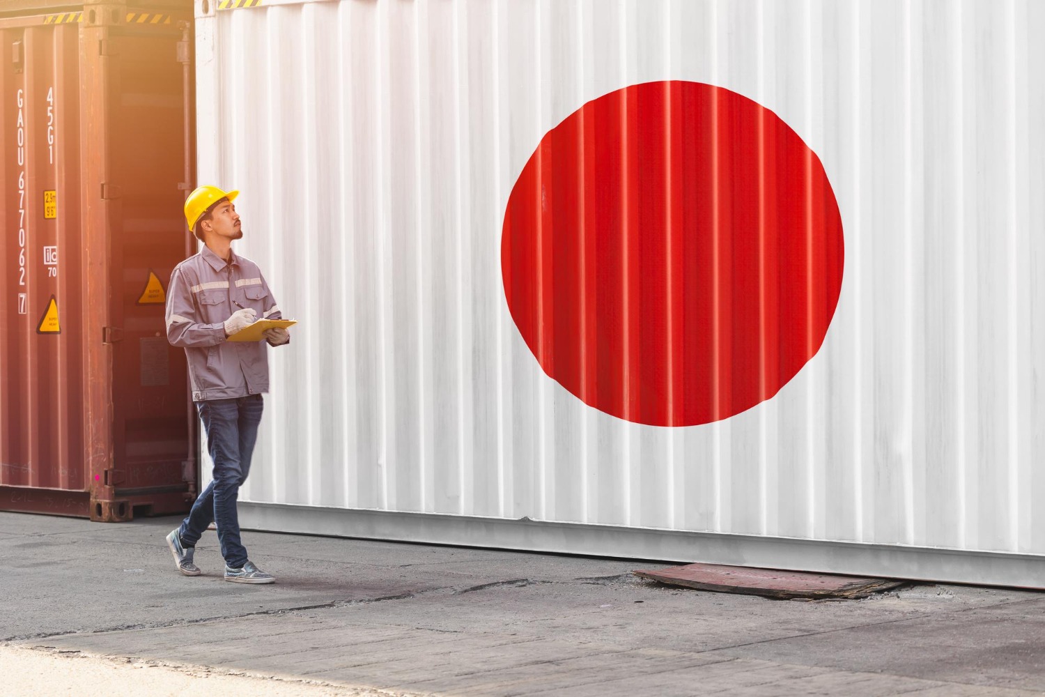 Alt text: Flag of japan paint on container with japanese male worker work in port cargo shipping logistic industry for country import export business concept