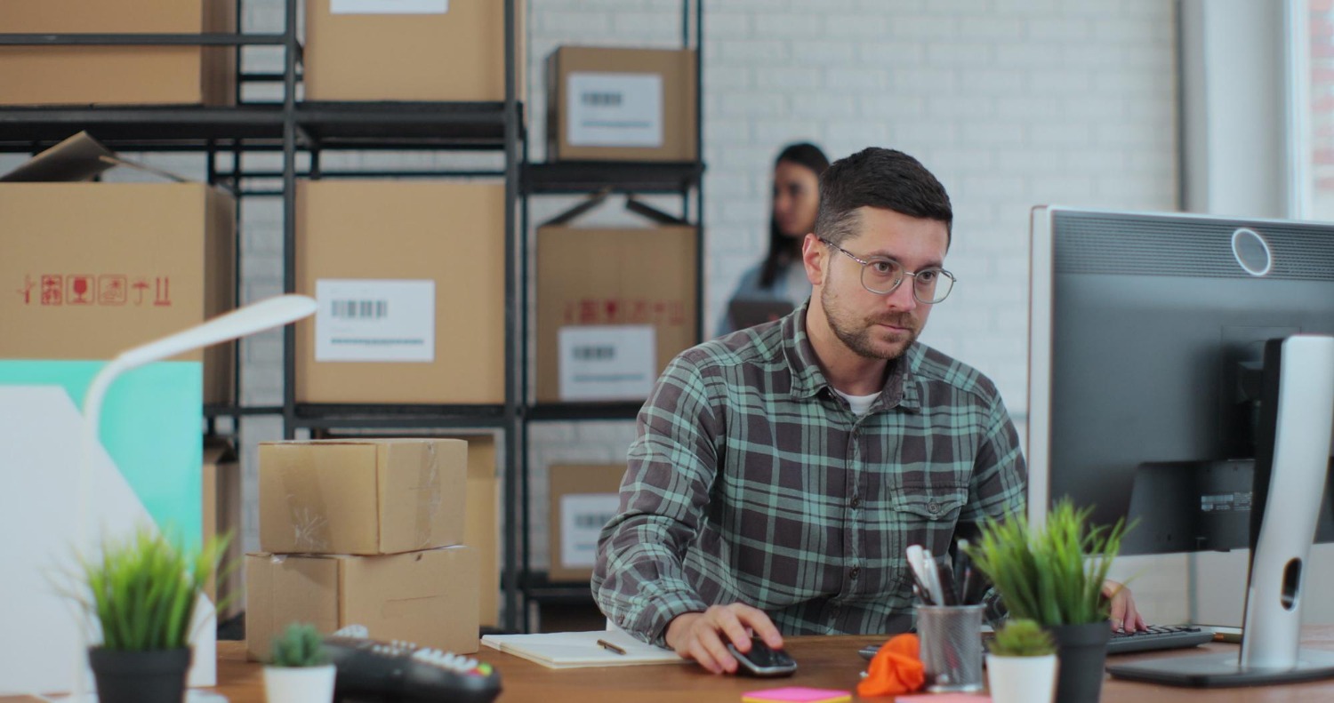 Alt text: A small business owner is calculating shipping costs for his packages.