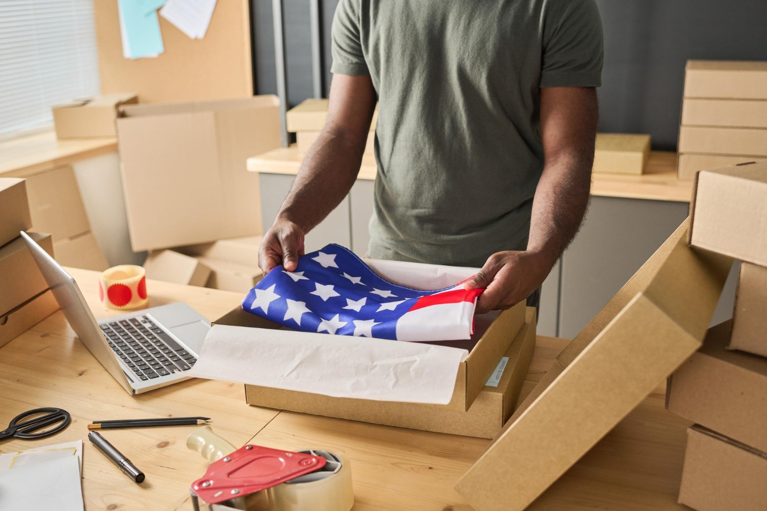 Alt text: A young woman is signing on a tablet as a package is delivered to her by a courier.
