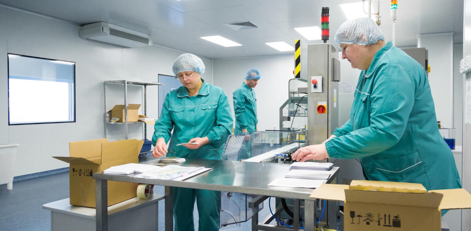 Alt text: Pharmaceutical workers are packing medical equipment into boxes.