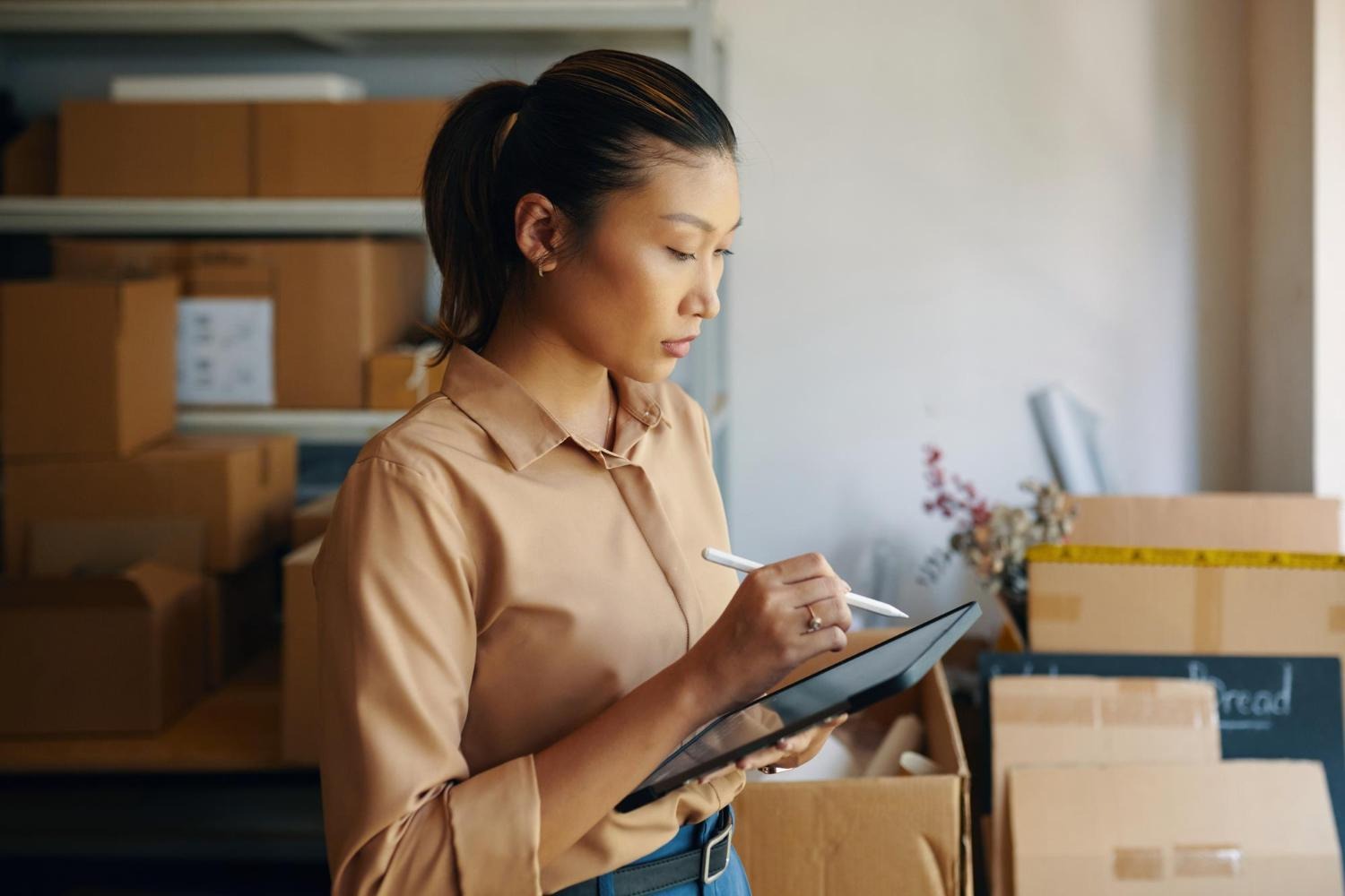 Alt text: A woman is checking inventory on a tablet.