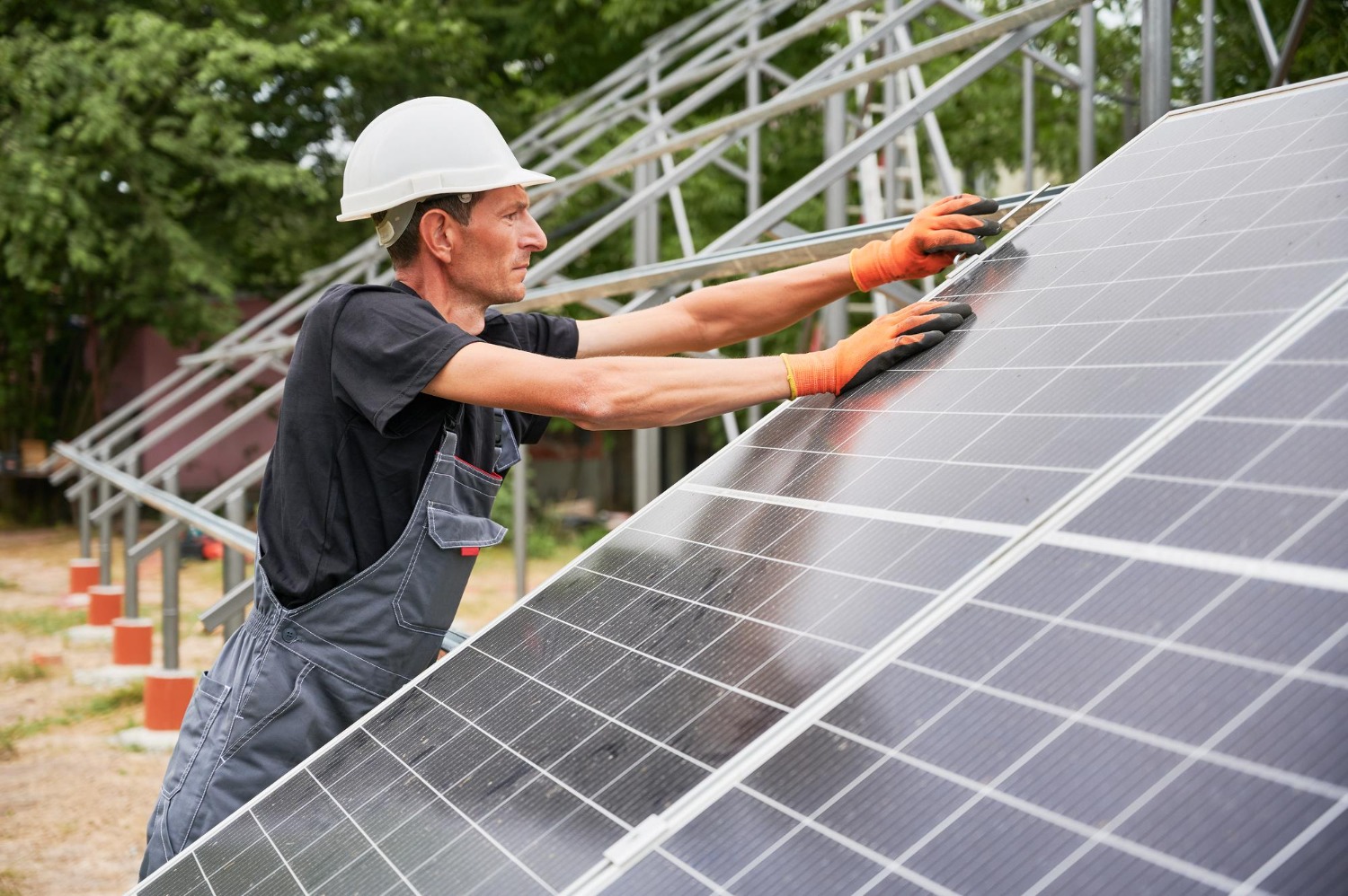 Alt text: Male worker installing a solar panel system.