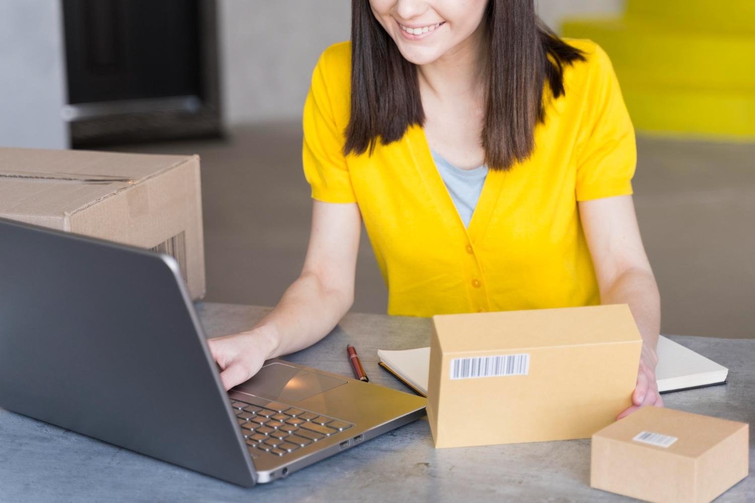 Alt text: A business owner is putting in details of her product into her laptop.