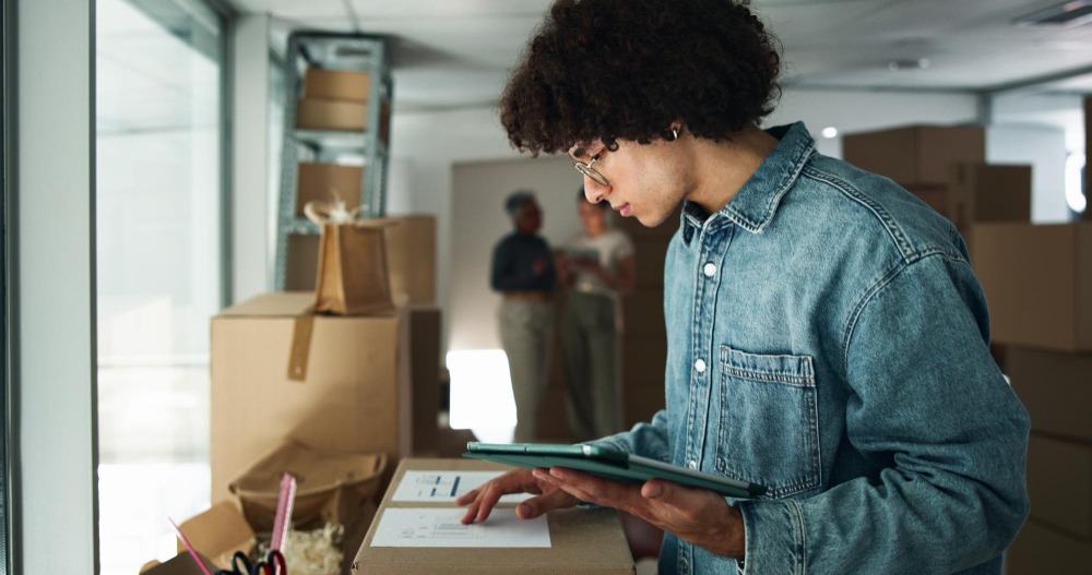 Alt text: Man inspects with a tablet for distribution logistics and an online checklist for package warehouse employees and service with digital for the e-commerce supply chain and info for orders.