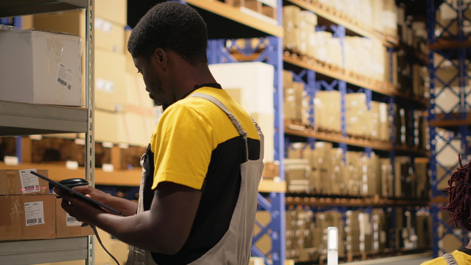 Alt text: Warehouse worker conducting inventory checks in a 3PL fulfilment warehouse.