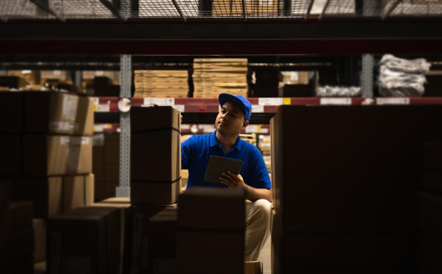 Alt text: Warehouse worker checking inventory with a tablet in a 3PL fulfilment warehouse for consumer packaged goods.