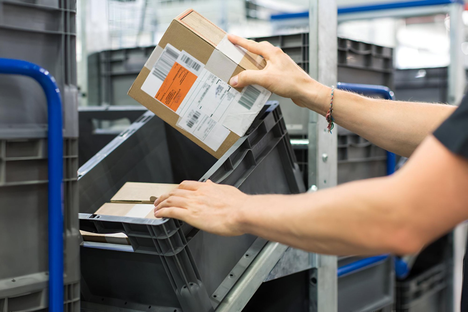 Alt text: Warehouse worker handling a labelled package during the order fulfilment process.