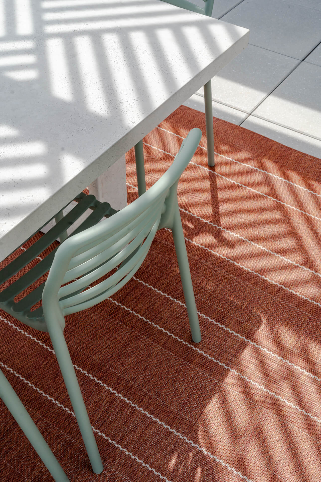 Green chair with orange rug in Continental Tower patio