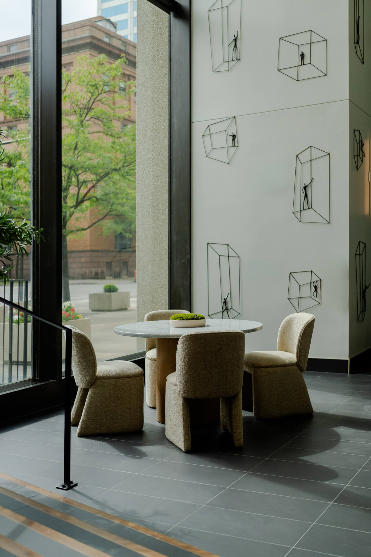 Table with green chairs and wall art in Continental Tower lobby