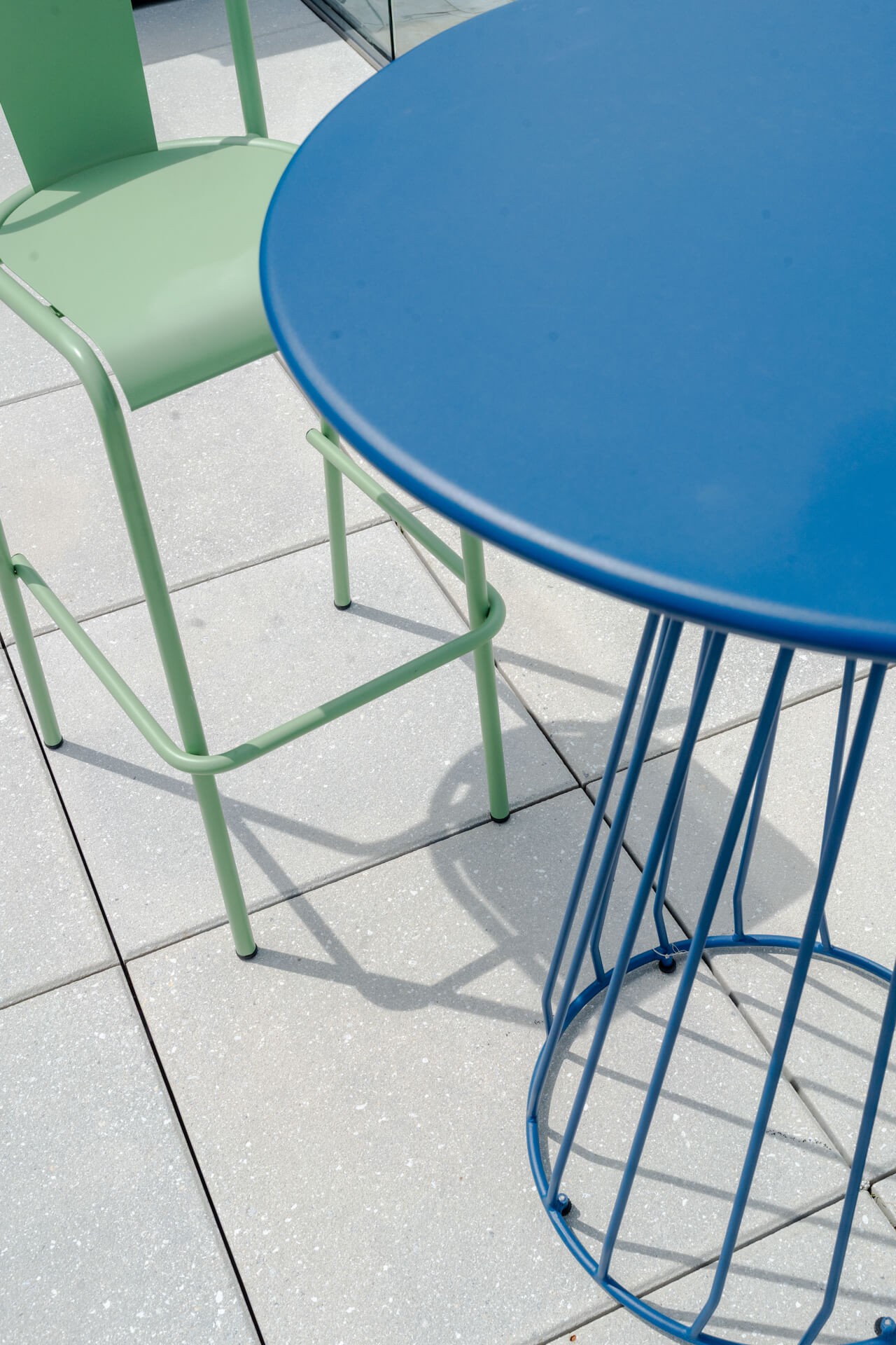 Blue table with green high top chair in Continental Tower patio