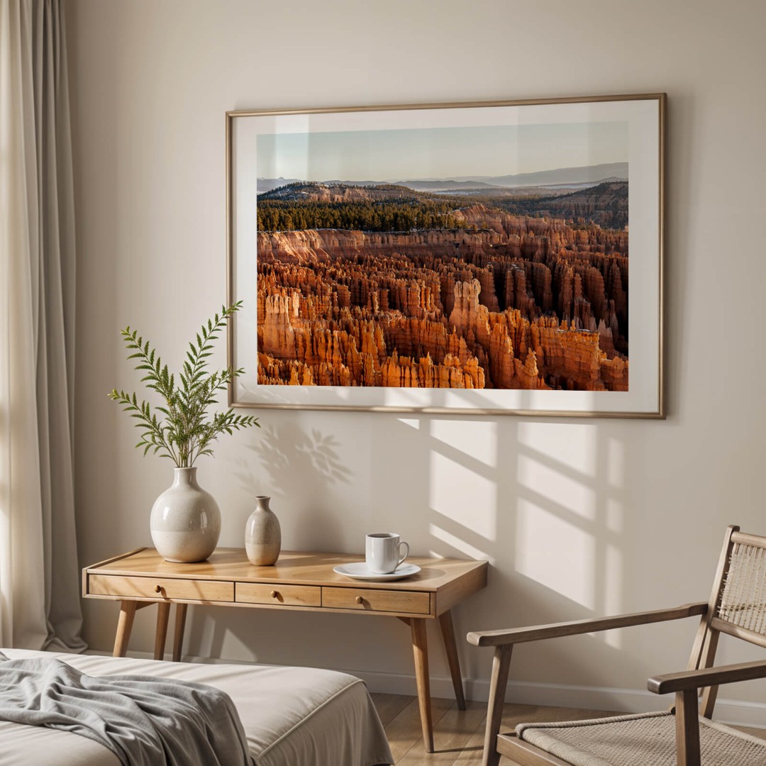 A framed photo of the hoodoo rock formations in Bryce Canyon on bedroom wall above a table