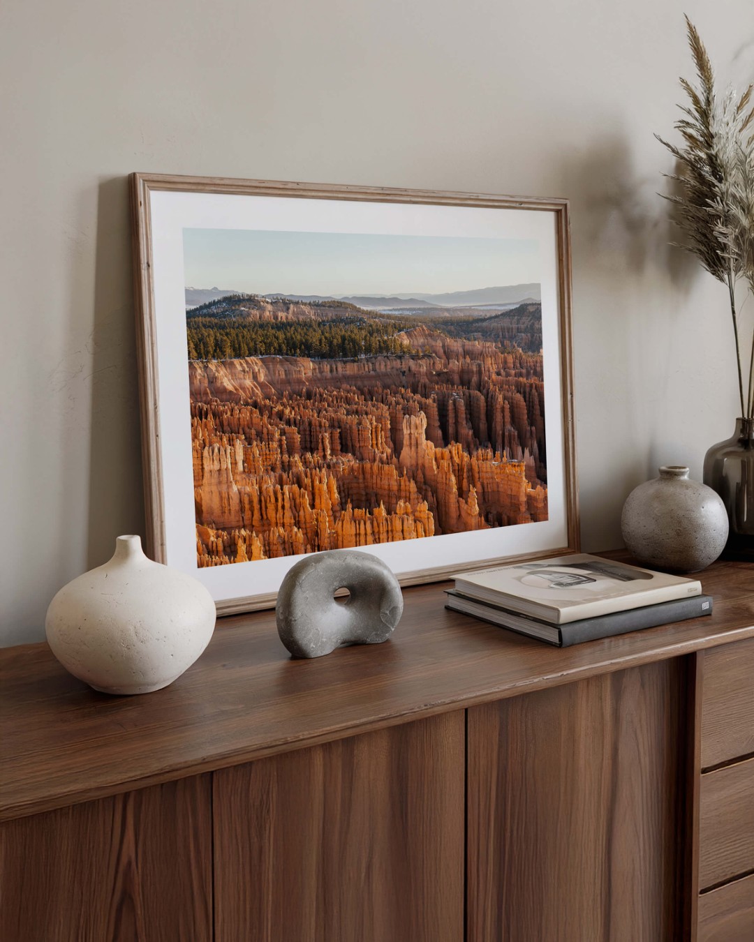 A framed photo of the hoodoo rock formations in Bryce Canyon sitting on top of a cabinet leaning against the wall