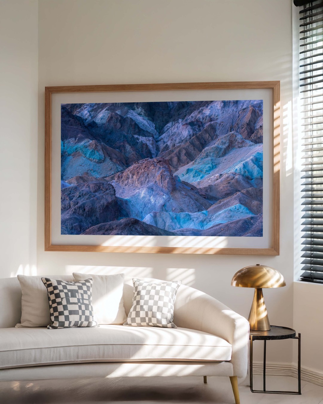 A framed photo of colorful rocky hills in Death Valley on a wall above a couch