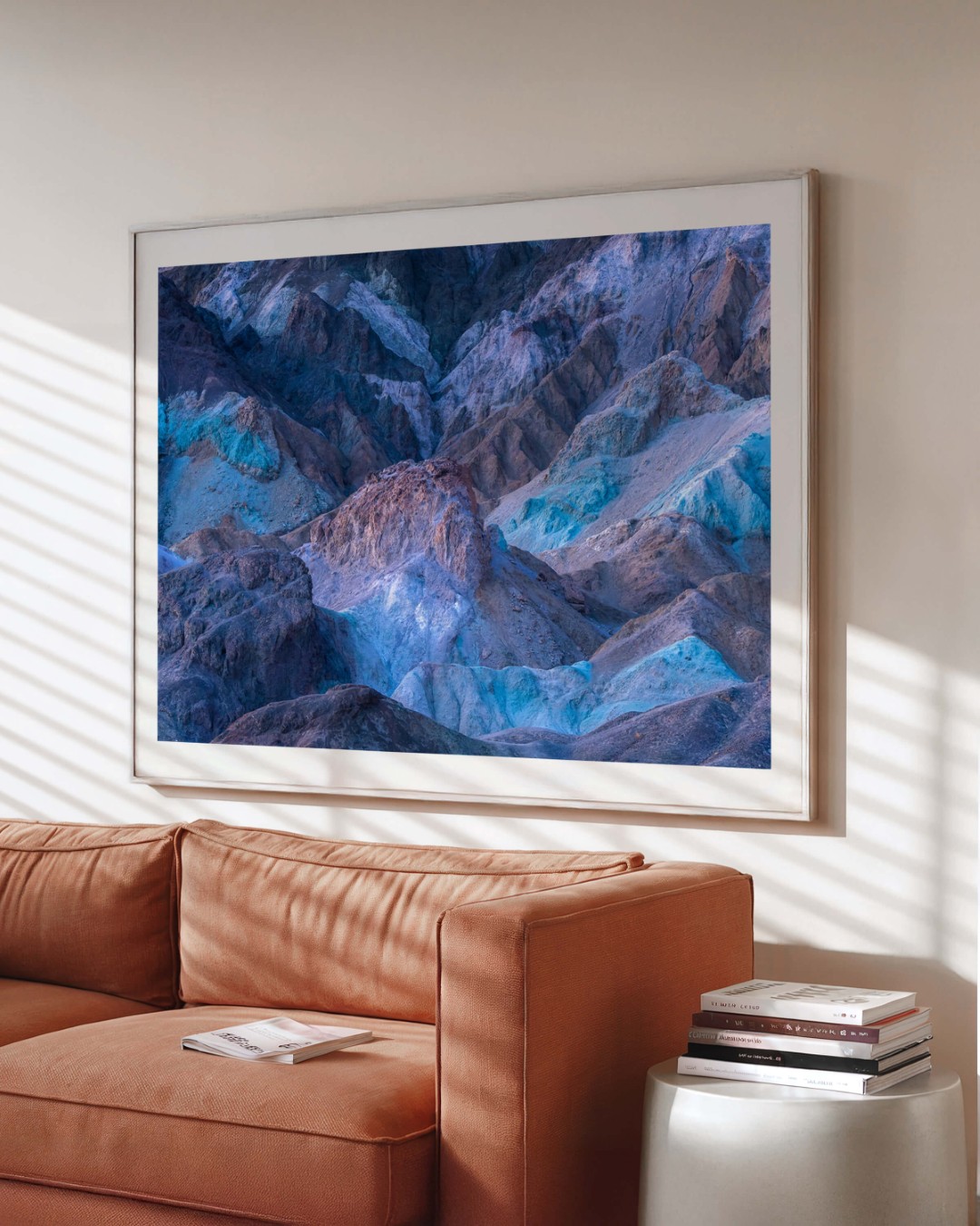 A framed photo of colorful rocky hills in Death Valley on a wall above a couch