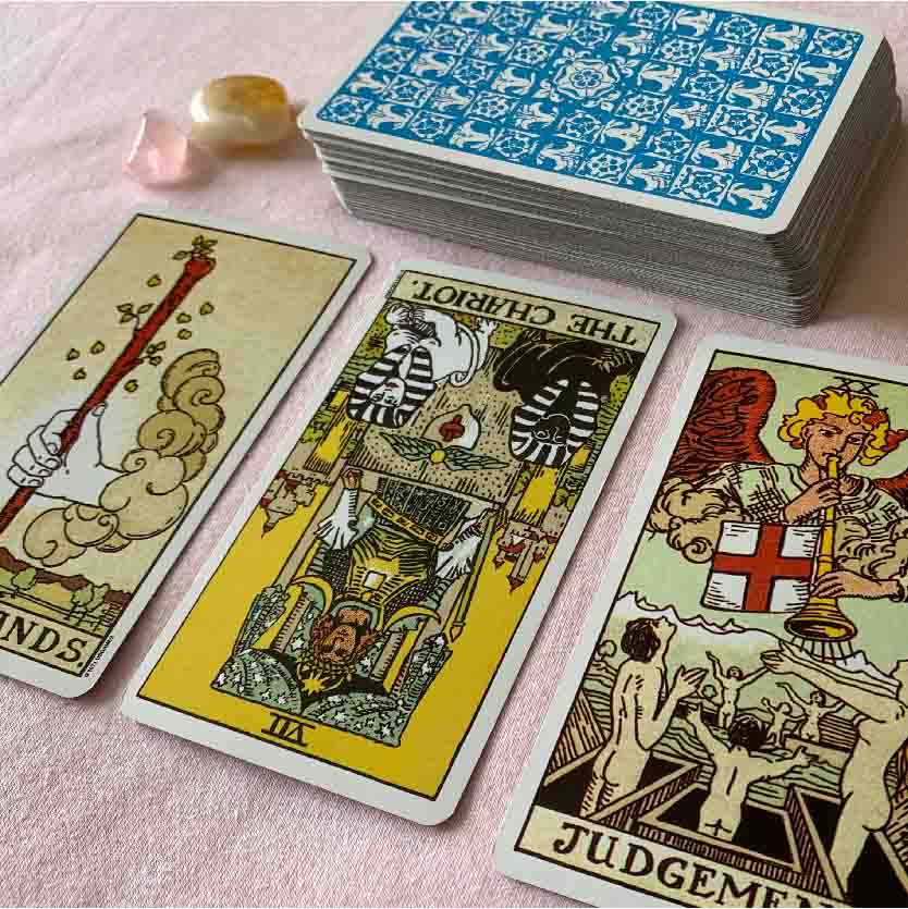 Bespoke tarot reading using many cards. Shown here is the ace of wands, the chariot and judgement, pictured with rose quartz and citrine. 