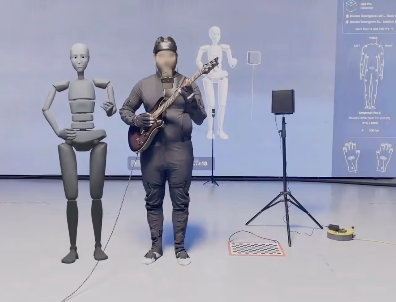 a man in full Rokoko motion capture gear, playing a guitar. Coil pro is right next to him which helps to capture precise finger movements.