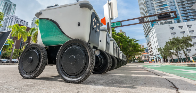 Autonomous delivery robots navigating a city street, highlighting robotics technology among the best robotics stocks.
