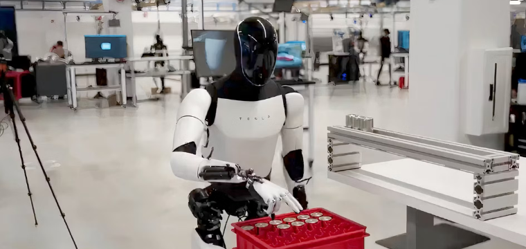Tesla humanoid robot handling components in a factory, highlighting Tesla among the best robotics stocks.