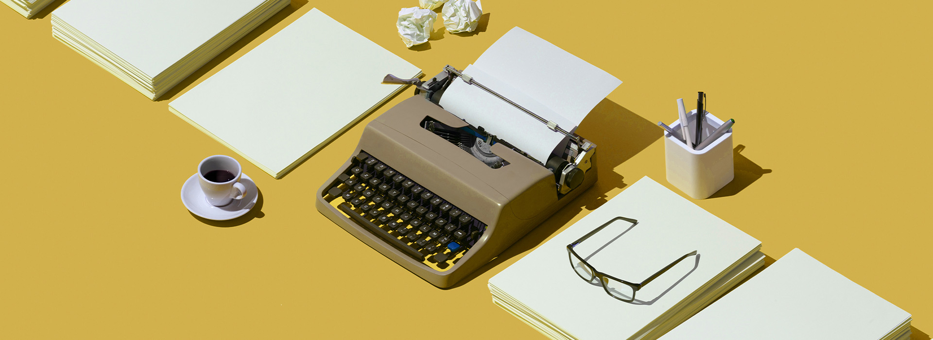 writer's desk: typewriter, papers, coffee and glasses