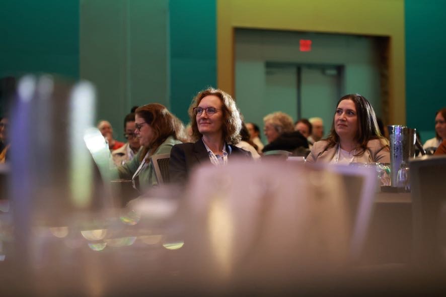 Audience members attentively listening during a leadership conference.