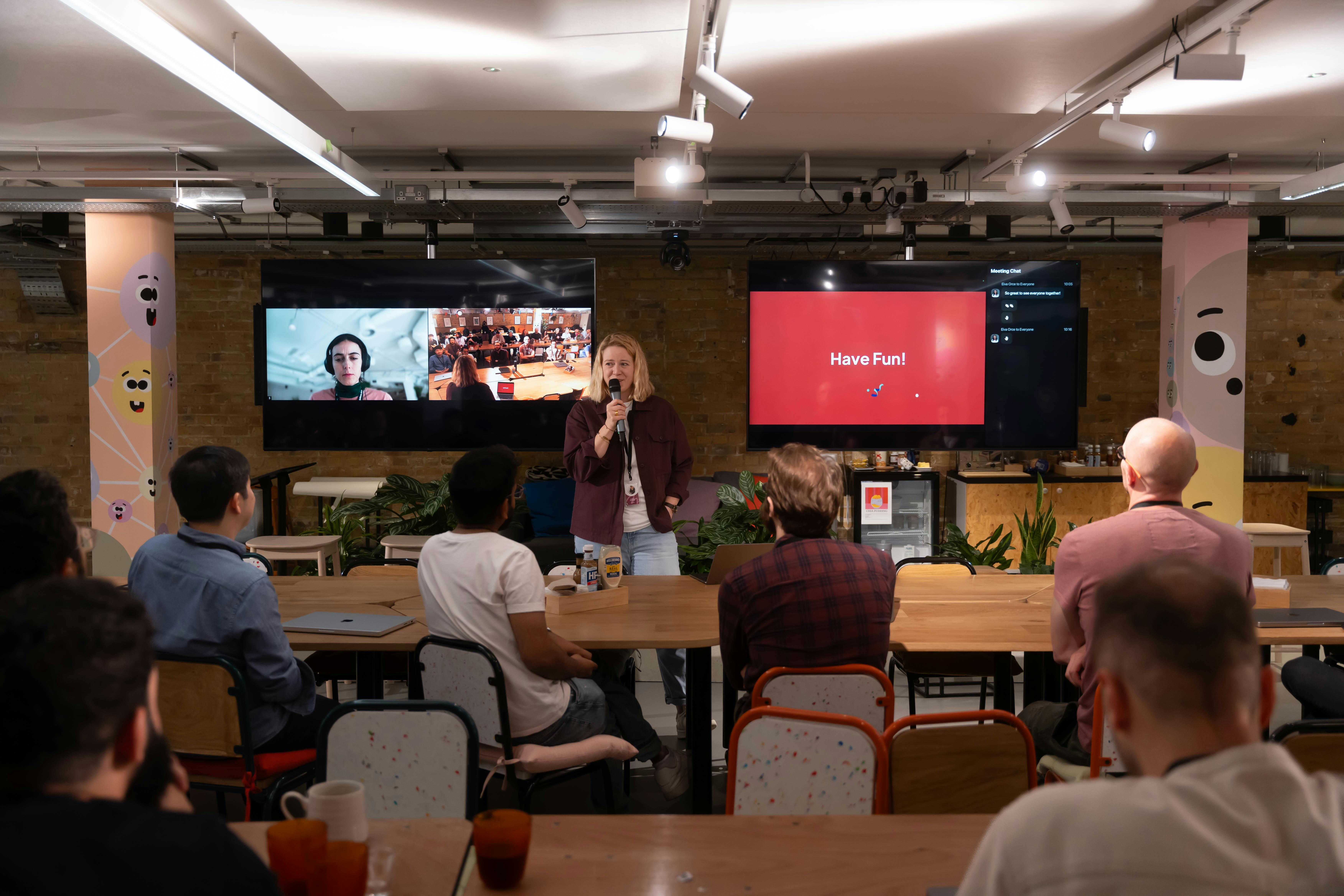 A professional team in an office setting, discussing strategy with one team member presenting ideas while others engage in conversation.
