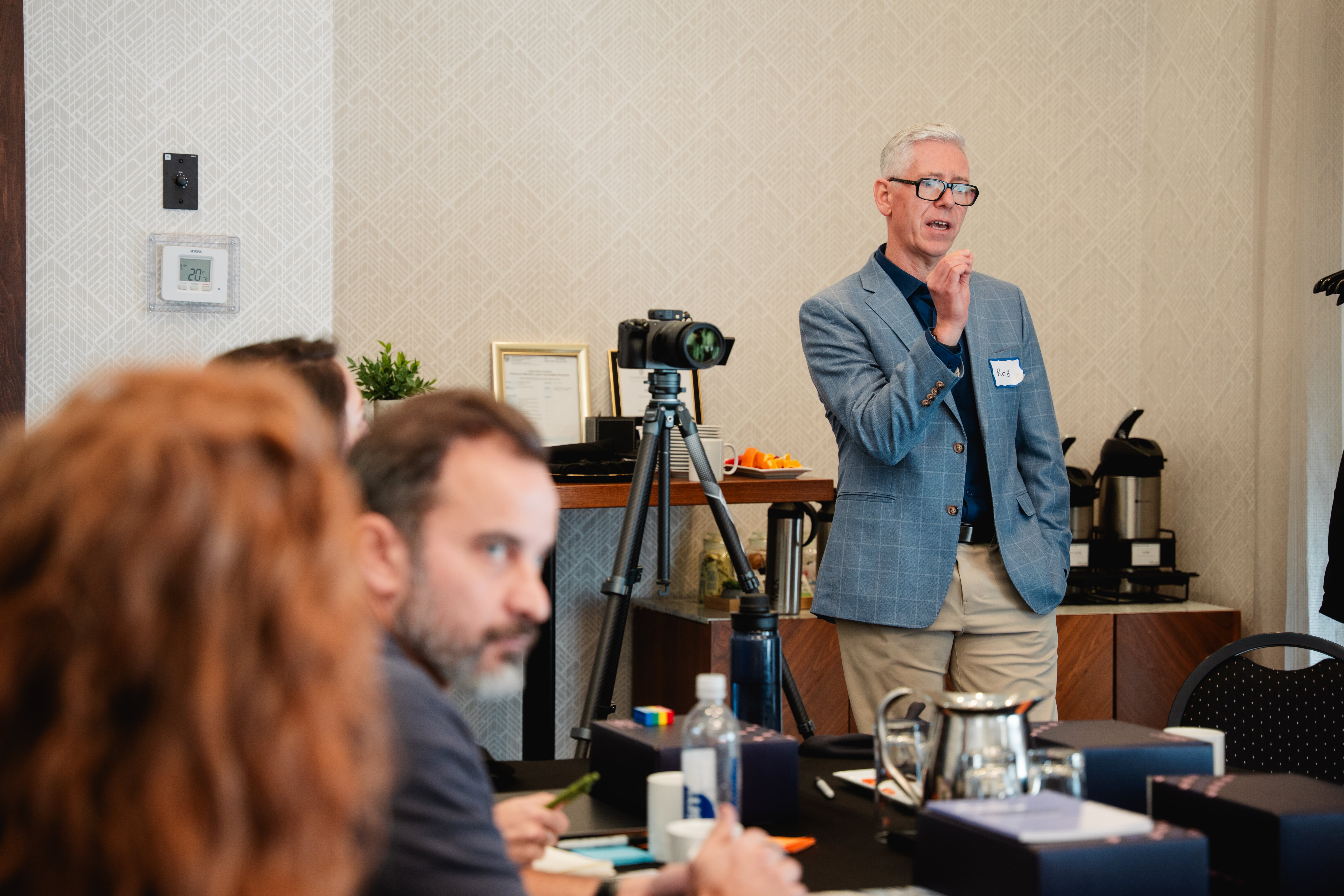 A leader speaking to colleagues seated at a conference table during a Unicorn Labs leadership workshop