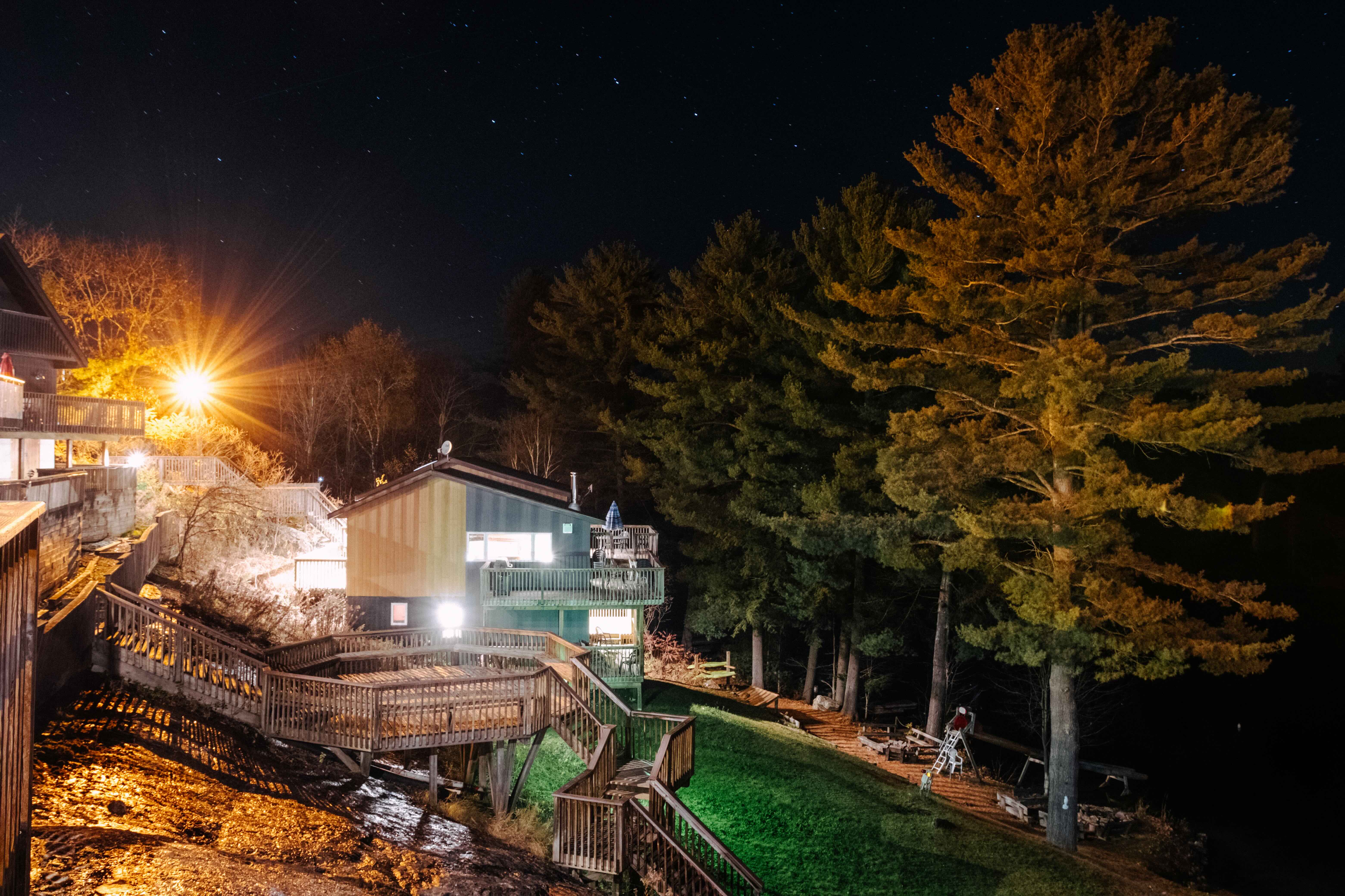 Wooded retreat lodge at night with lit decks and staircases under a starry sky, an offsite venue for leadership team planning sessions