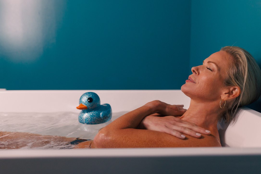 Guest relaxing with eyes closed in the private cold plunge at sēk Sauna Studio in Franklin, Tennessee.