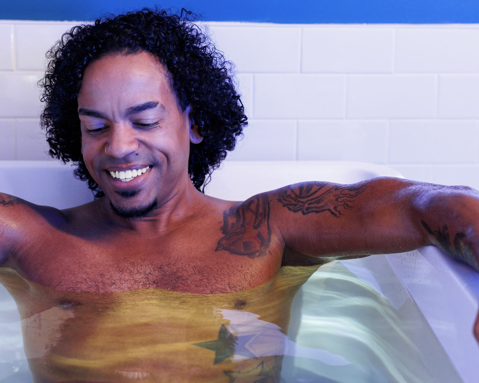 Guest smiling in the cold plunge tub during a private session at sēk Sauna Studio in Franklin, Tennessee.