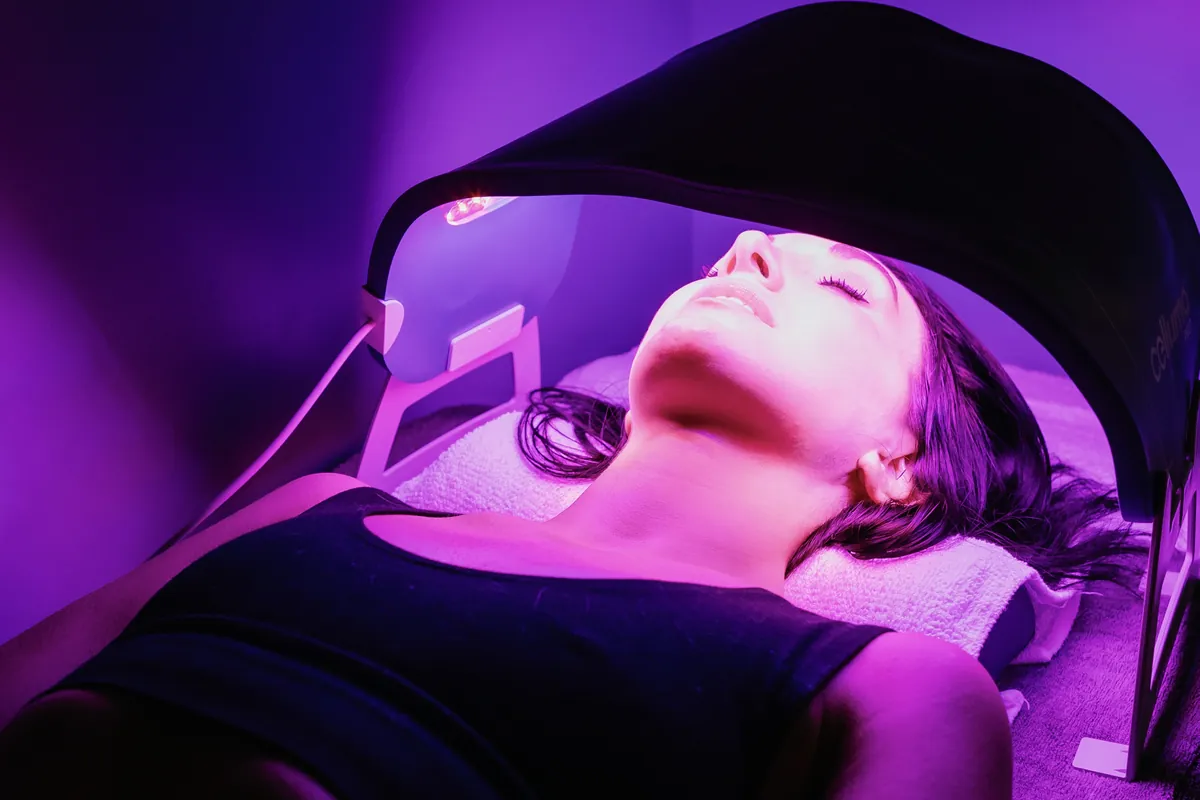 Guest relaxing under a Celluma PRO panel during a red light therapy session at sēk Sauna Studio in Franklin, Tennessee.