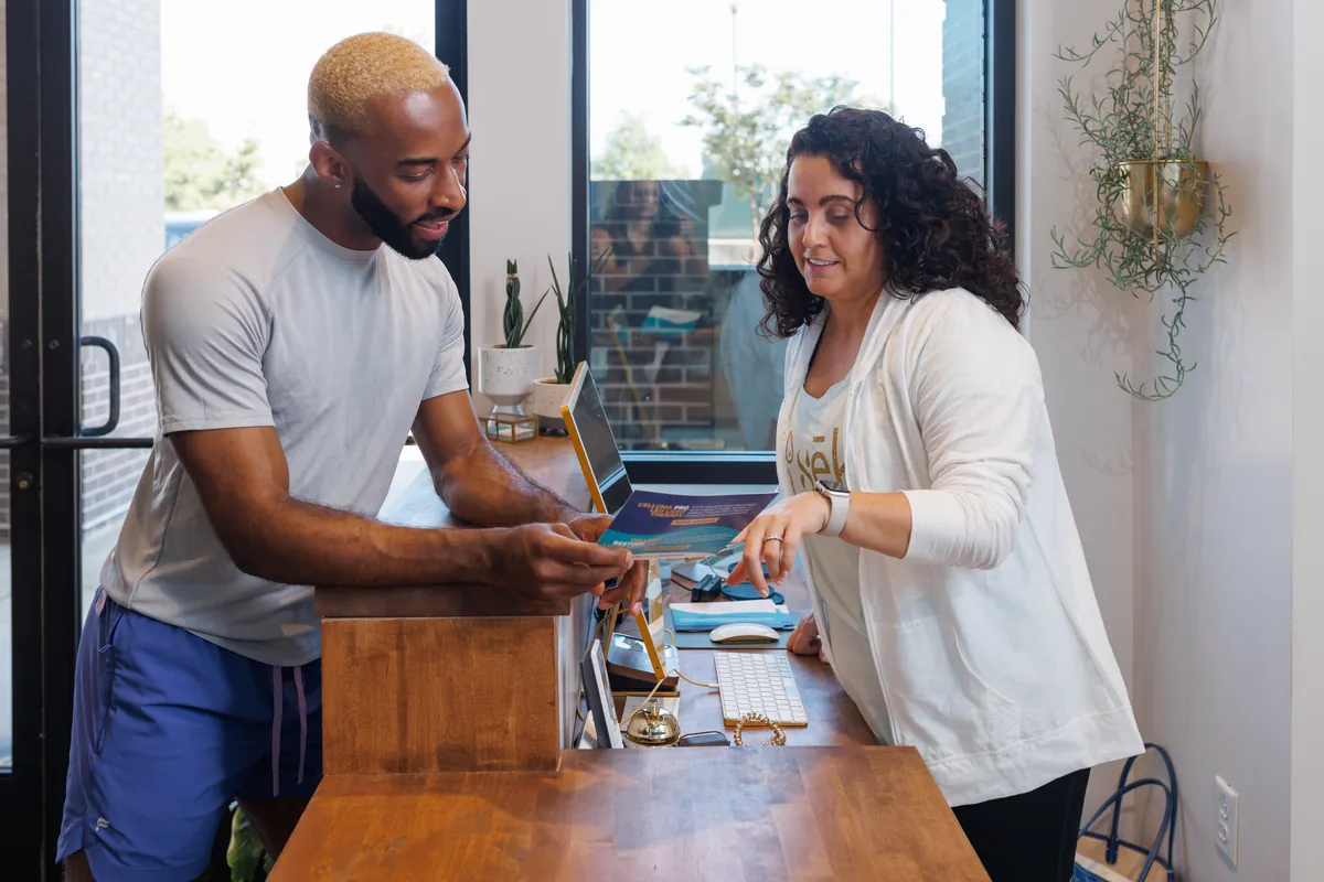 sēk Specialist helping a guest choose a first session at the front desk