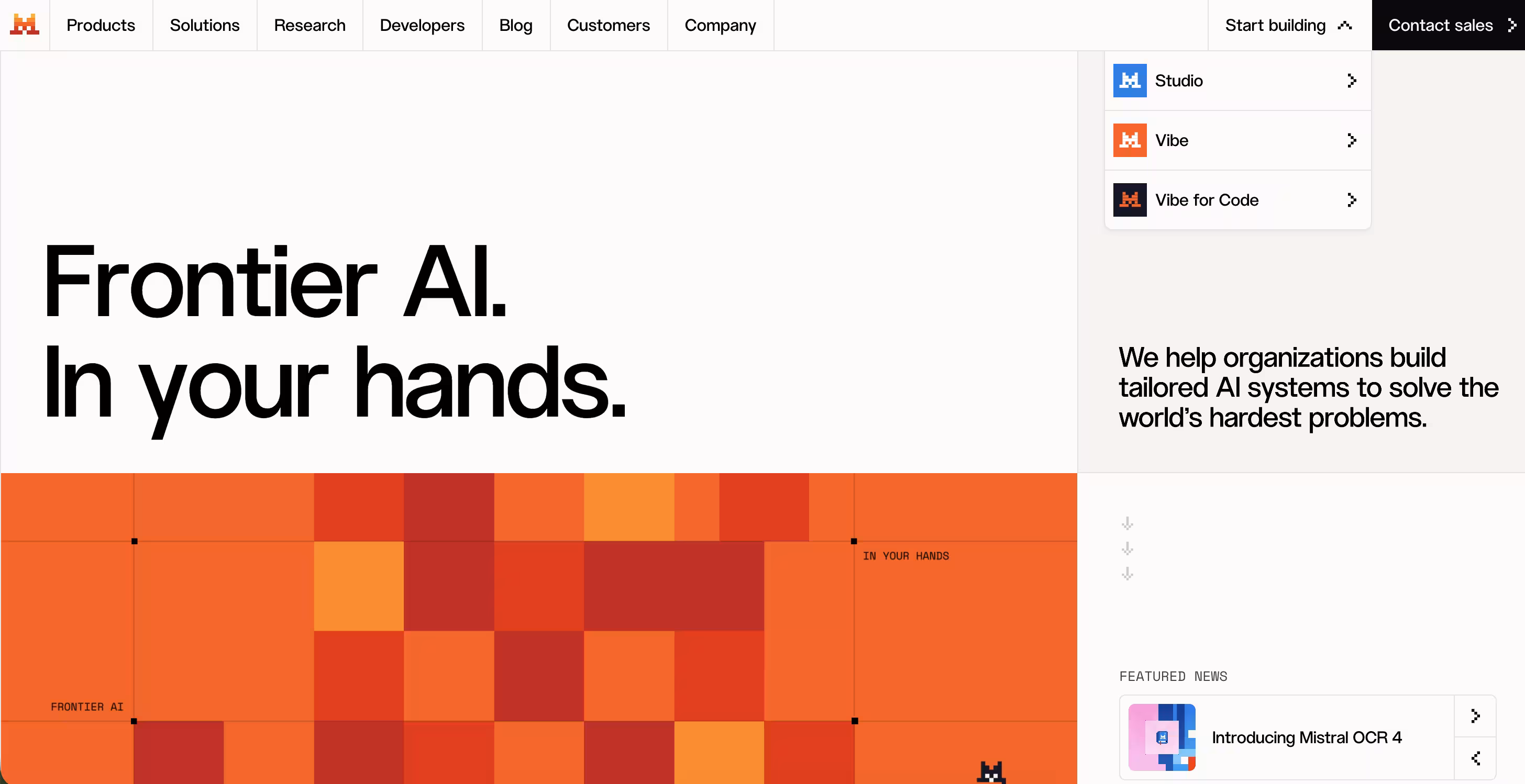 Screenshot der Homepage von Mistral AI mit dem Slogan „Frontier AI. In your hands.“ sowie einem geöffneten Dropdown-Menü, das die Produkte „Studio“, „Vibe“ und „Vibe for Code“ anzeigt.