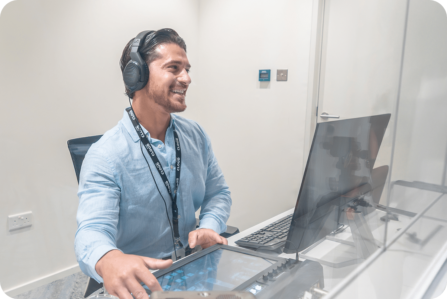 A public speaker presenting to a seated audience on wooden chairs