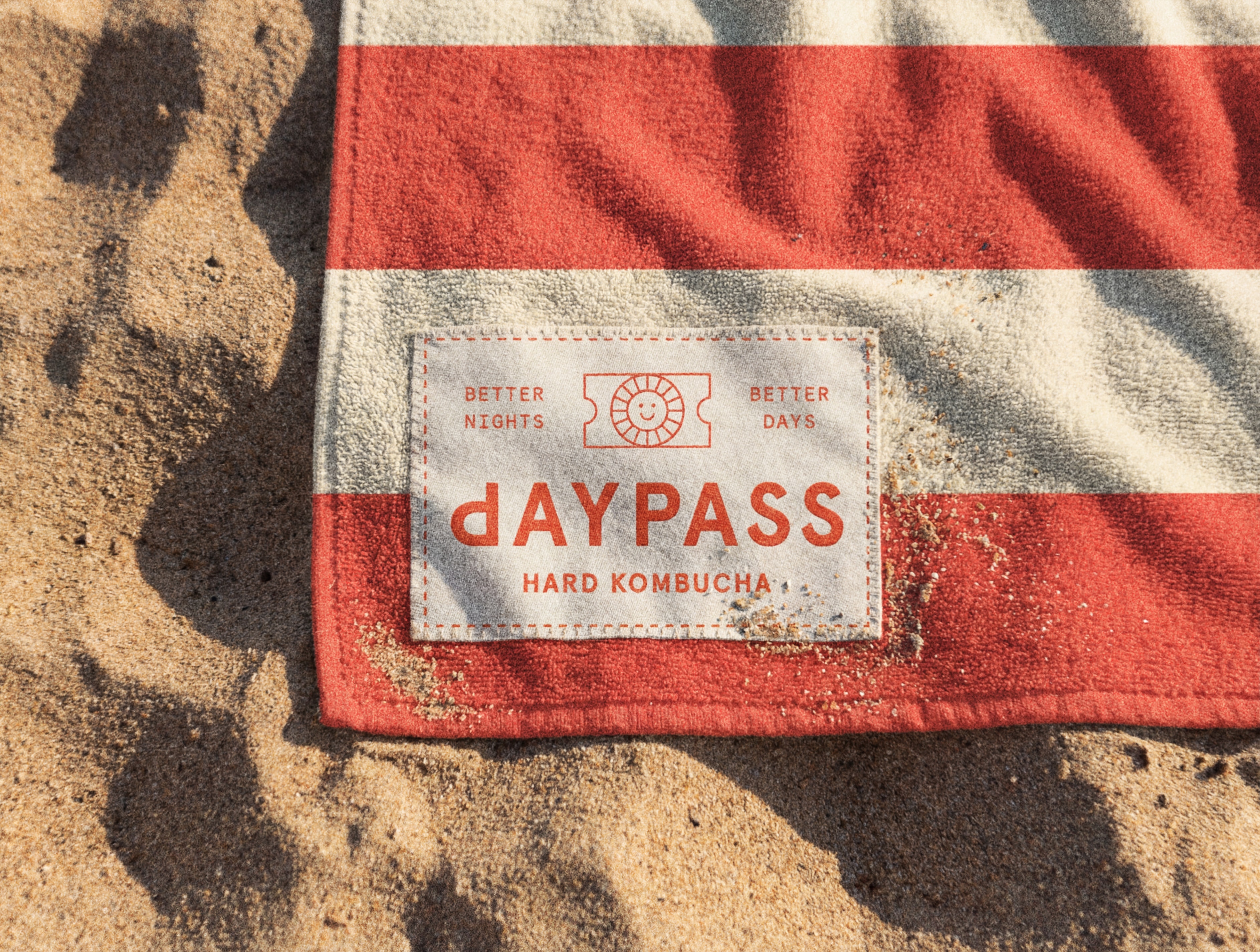 Daypass branded towel label sitting in the sand