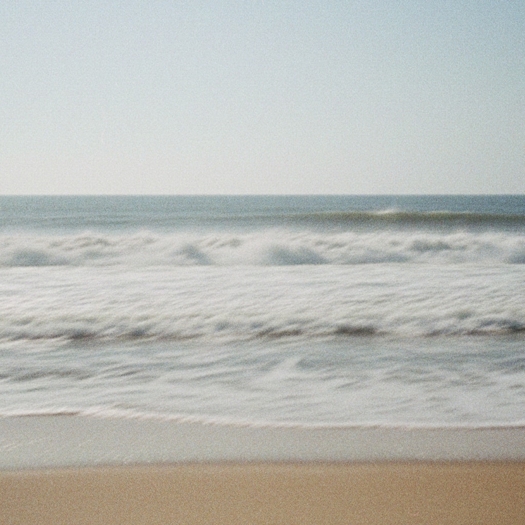 Film photo of ocean waves crashing on shore
