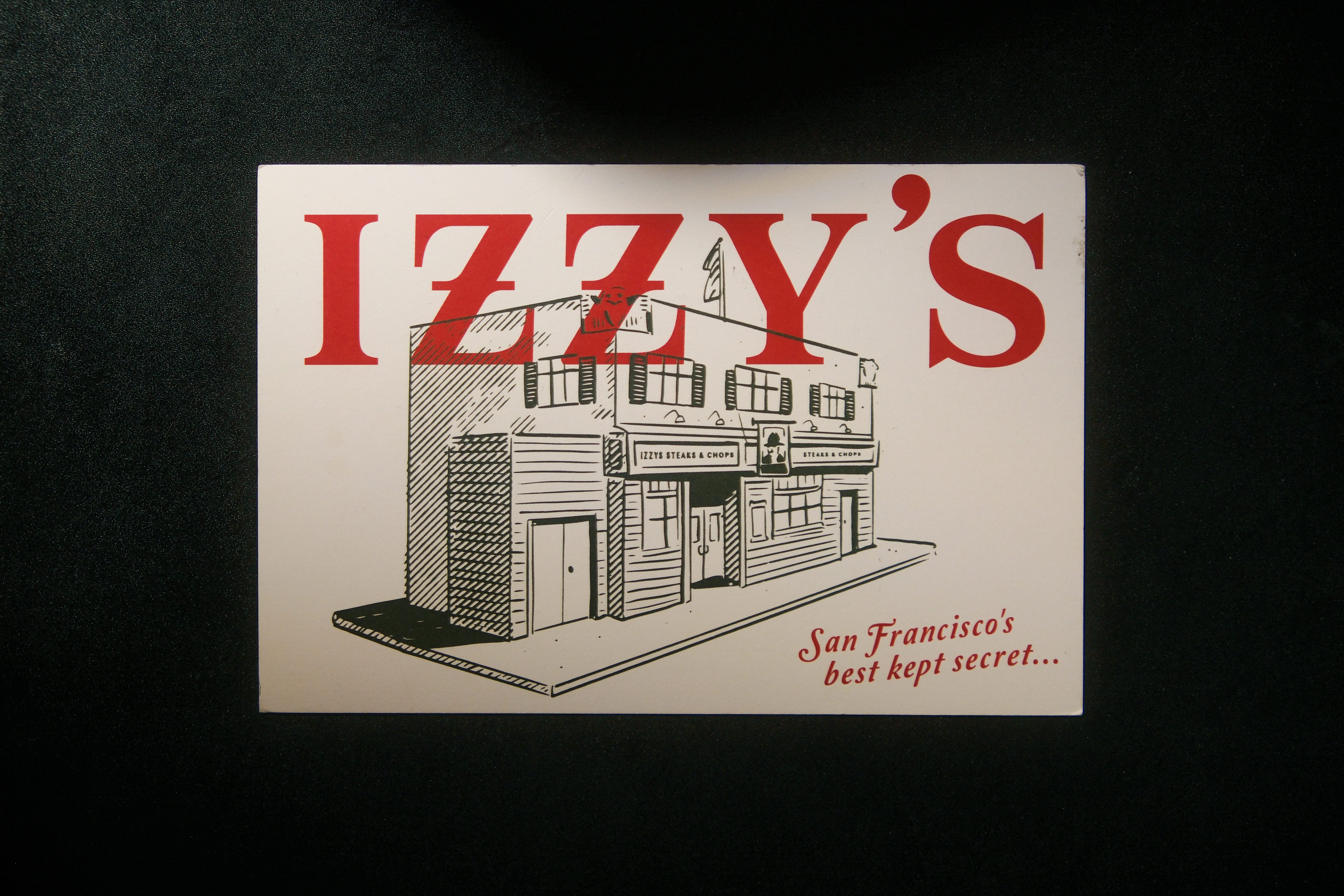 Izzy's Steaks & Chops postcard with illustrated building exterior and tagline 'San Francisco's best kept secret'