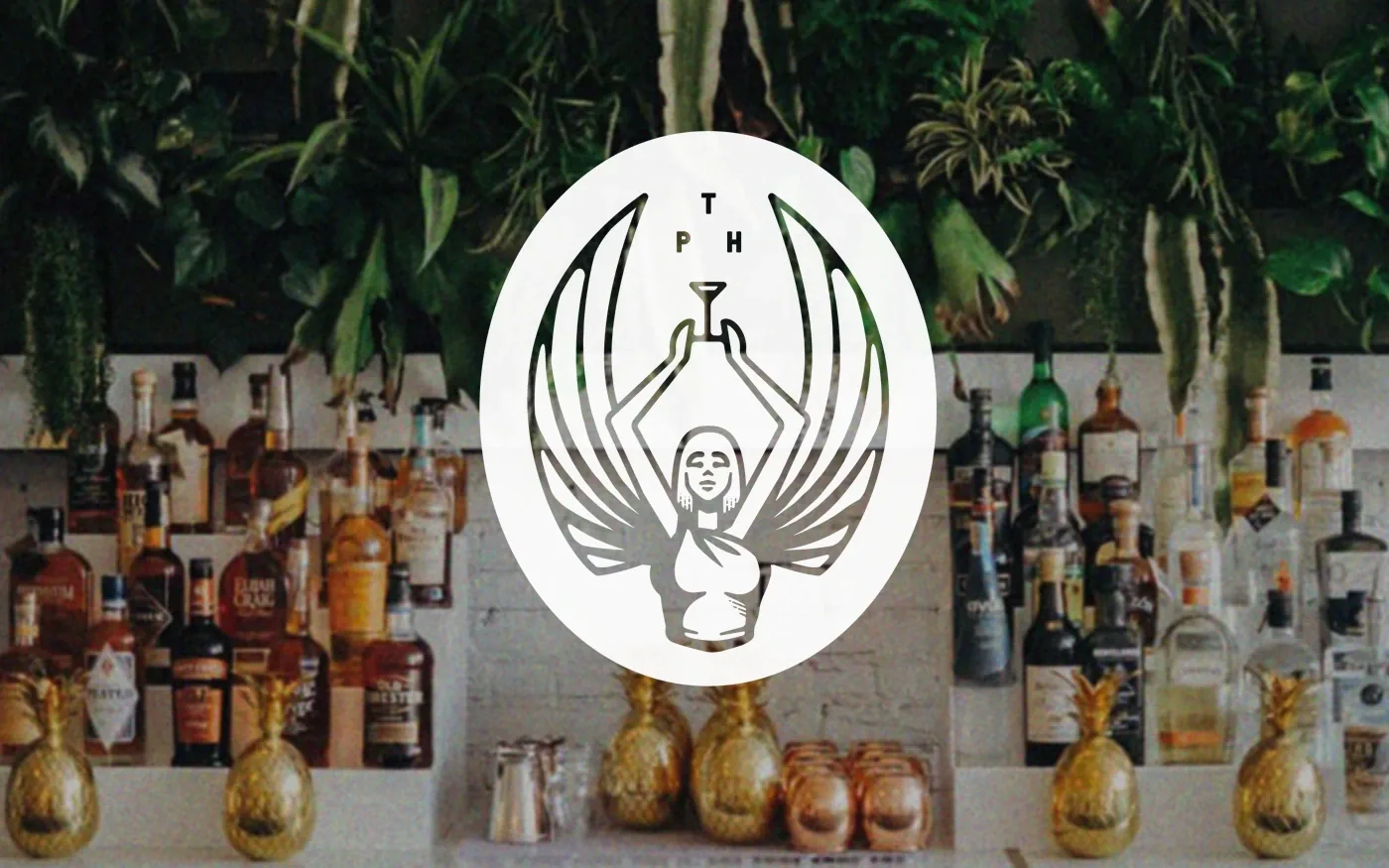 The Public House oval goddess logo in white overlaid on a full bar shelf with liquor bottles and gold pineapple decorations