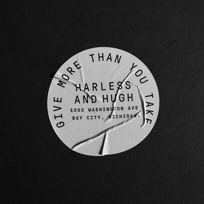 Circular Give More Than You Take Harless and Hugh sticker on a dark background