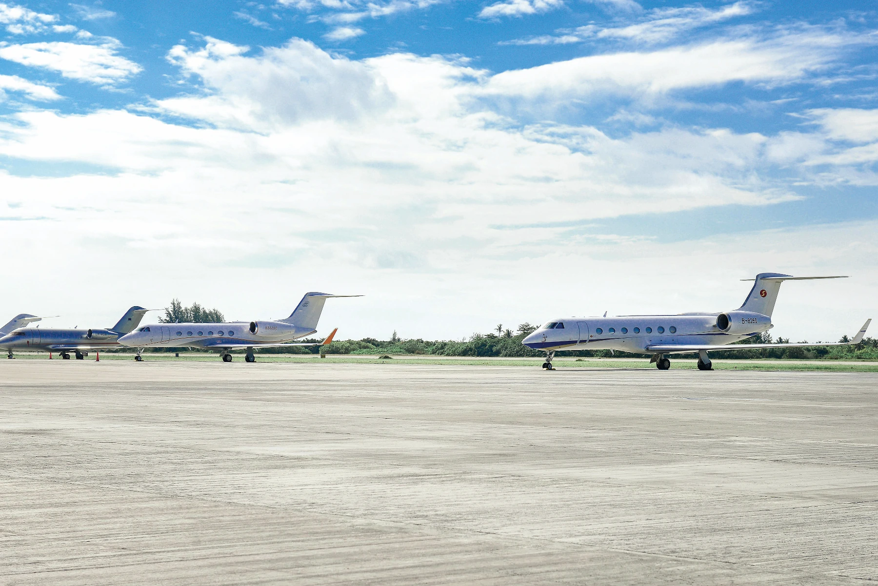 Varios jets privados aparcados en un aeródromo.