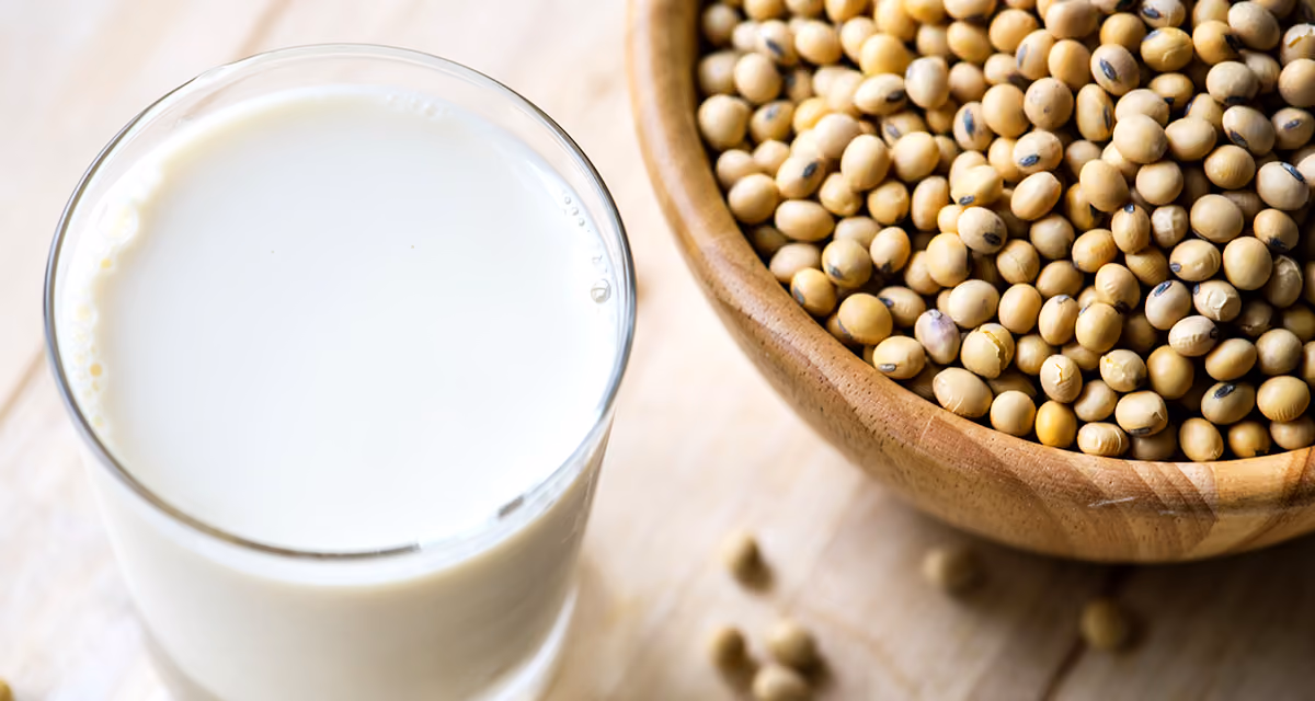 Bol de graines de soja accompagné de produits dérivés, sources de protéines végétales et d'isoflavones aux multiples bienfaits pour la santé.