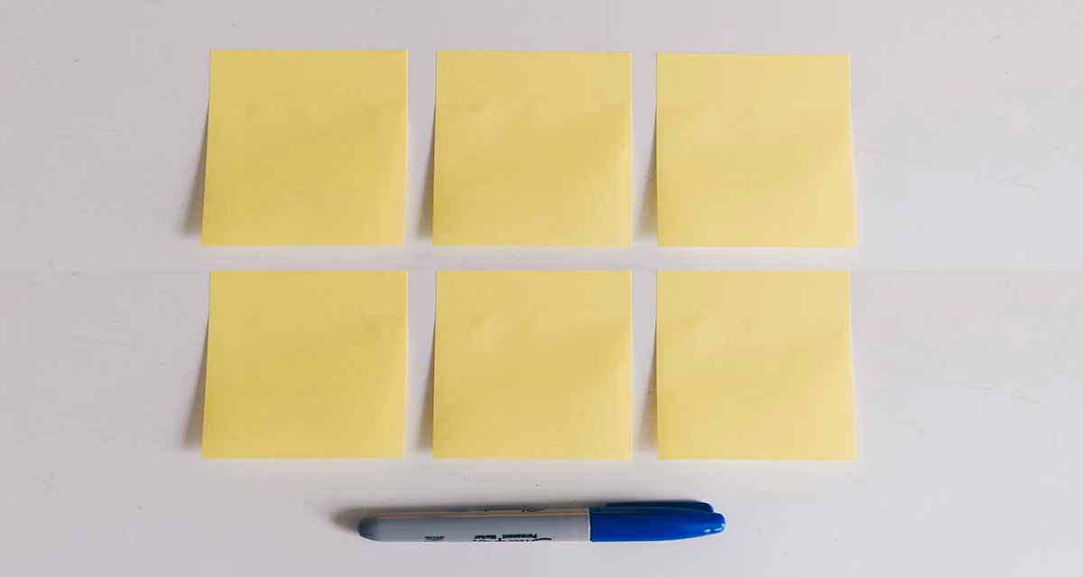 Six post-it et un stylo collés sur un tableau, pour noter ses bonnes résolutions santé de la nouvelle année