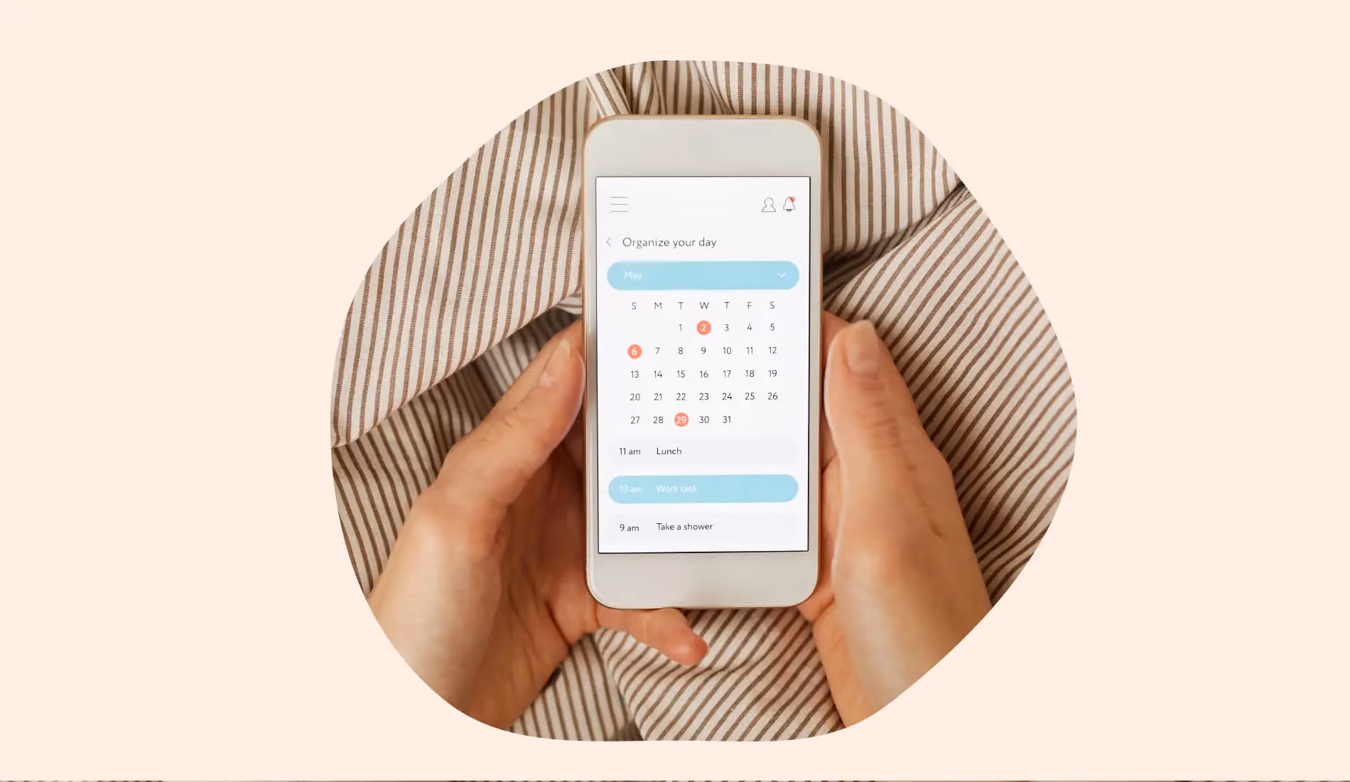 Mains tenant un smartphone affichant un calendrier menstruel, utilisé pour suivre l'ovulation et la fertilité.