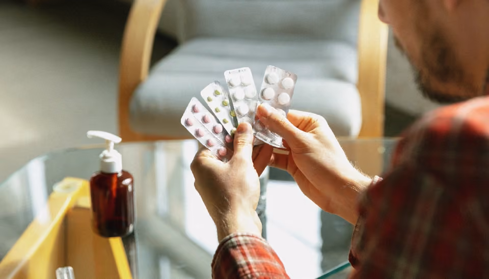 une main qui tient des tablettes de médicaments