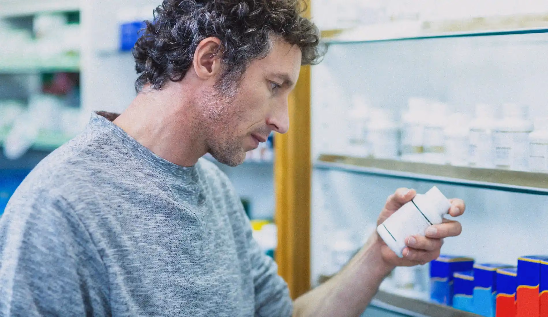 Un homme debout tient une boîte de médicaments antihistaminiques dans sa main gauche