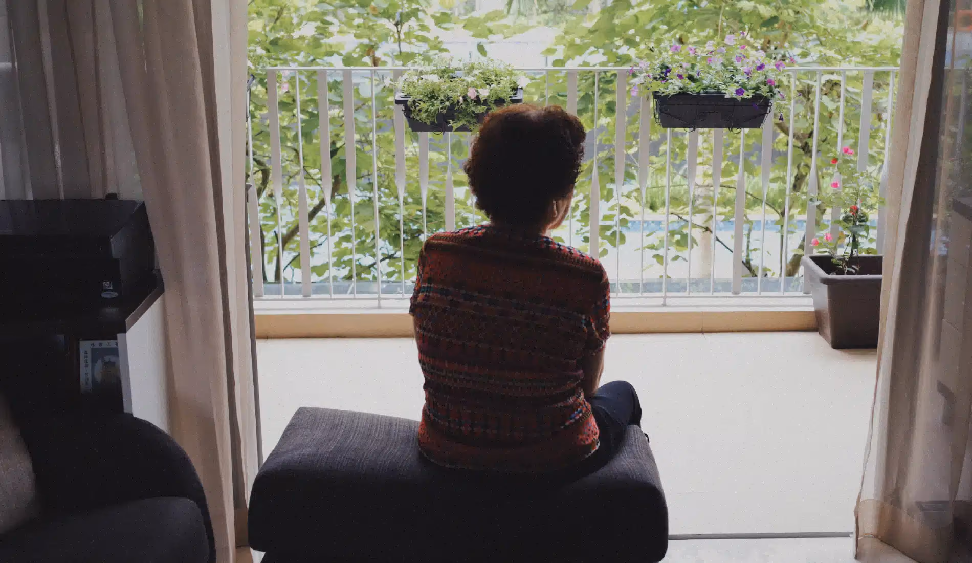 Femme assise de dos sur un pouf, illustrant le repli sur soi et le mal-être silencieux associés à l'hypocondrie
