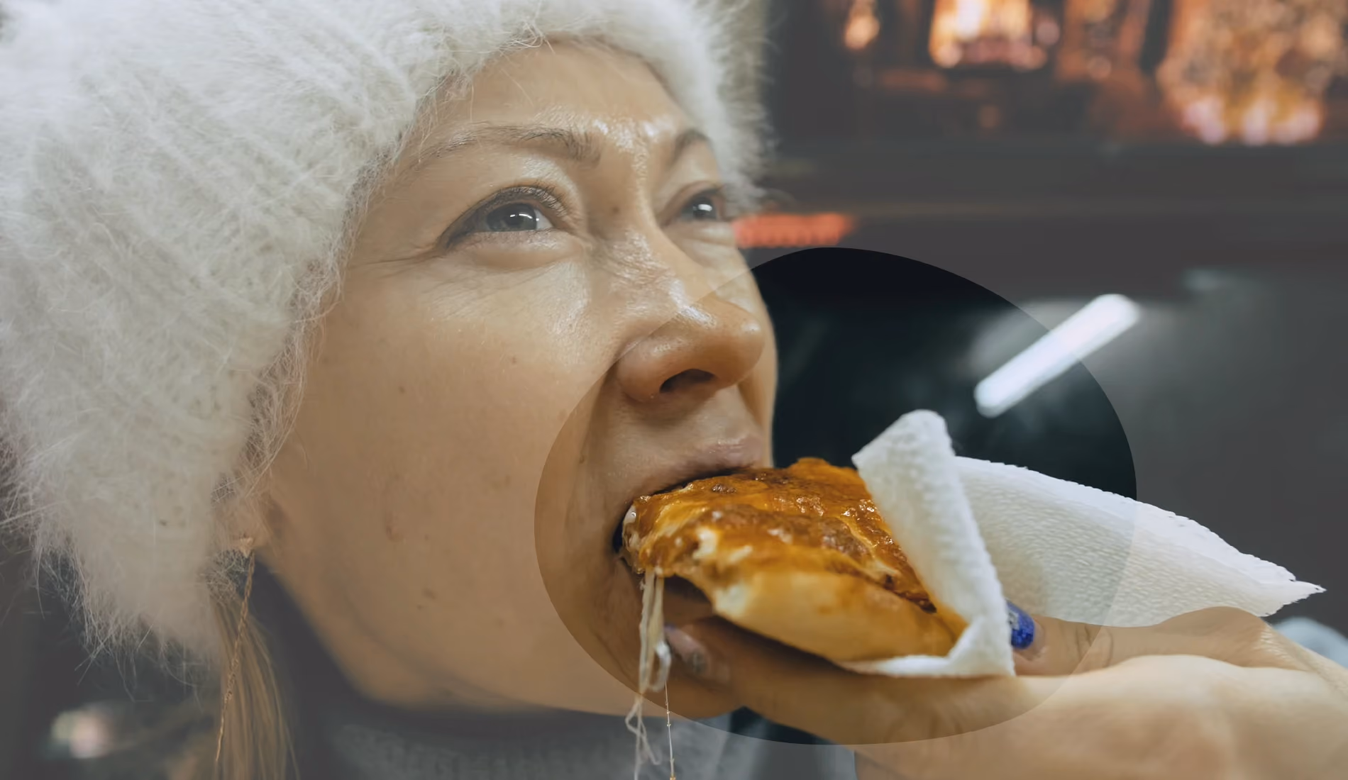 Une dame qui mange une part de pizza pour illustrer cet article sur l'ostéoporose.