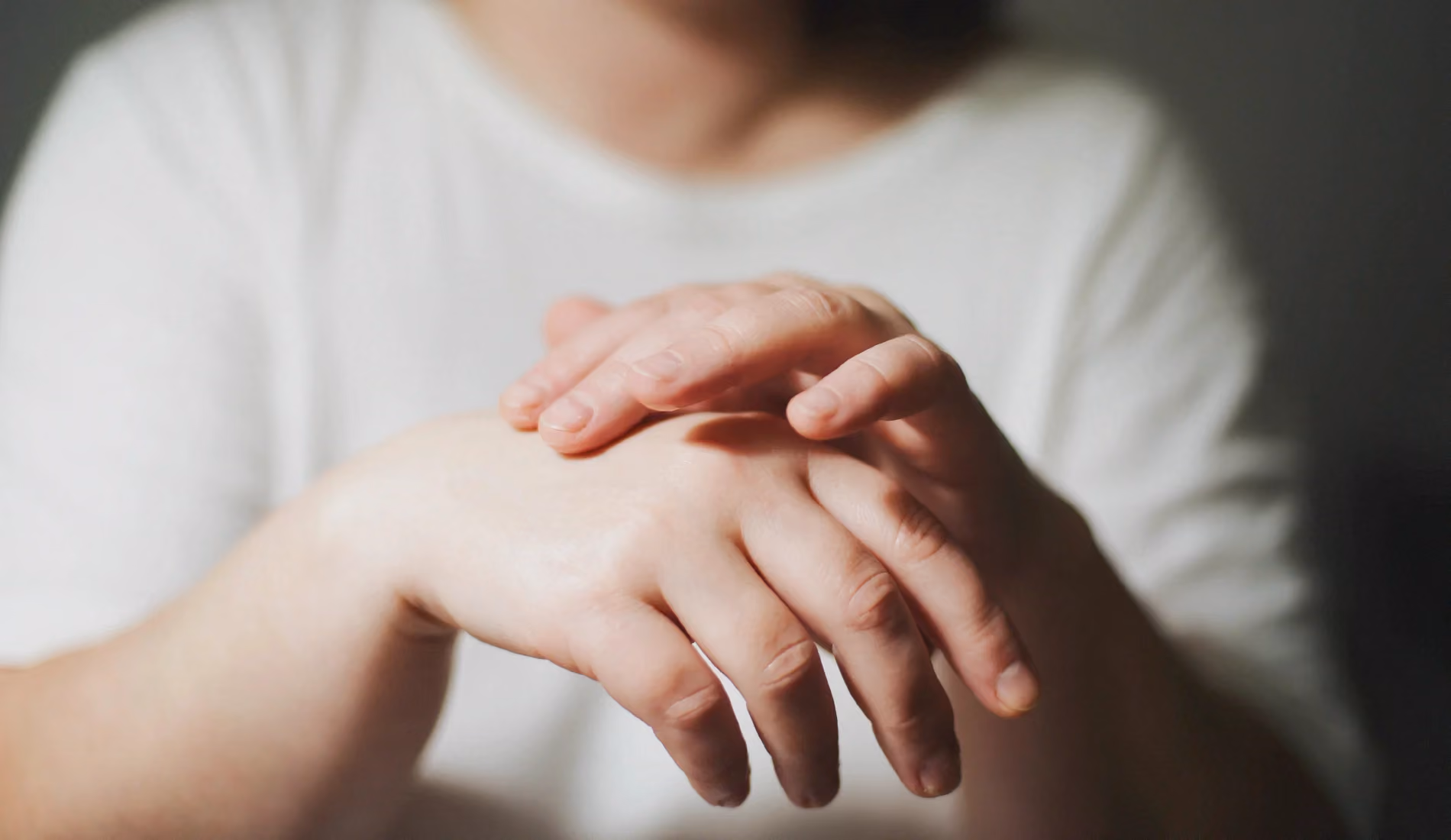 Une personne serrant ses mains gonflées